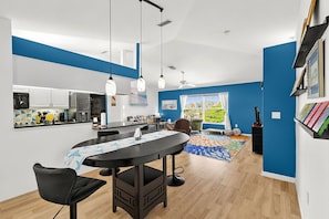 Une cuisine moderne avec un coin repas, un ventilateur de plafond et une vue sur l’extérieur.