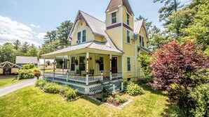 A two-story house with a porch and a tower.