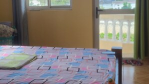 Ein Zimmer mit einem Bett, einem Fenster und Blick ins Freie.