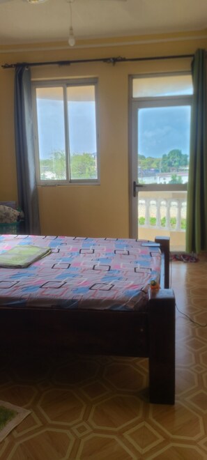 Ein Zimmer mit einem Bett, einem Fenster und Blick ins Freie.