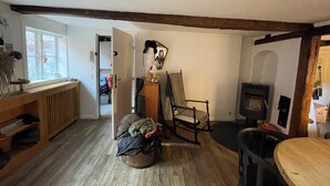 A cozy room with a wooden floor, a rocking chair, a table, and a fireplace.