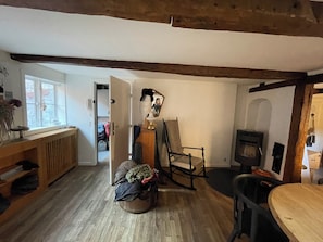 A cozy room with a wooden floor, a rocking chair, a table, and a fireplace. - Charming and historic apartment in the city center! (København)