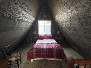 A room with a bed, two bedside tables, a chair, and a window. - Cozy A-Frame Cabin on Turtle Lake - Sleeps 4, Steps from your private sand beach (Lake Park)