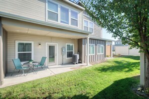 Un immeuble résidentiel de deux étages doté d’un patio couvert, d’un espace extérieur aménagé pour s’asseoir et d’une pelouse.