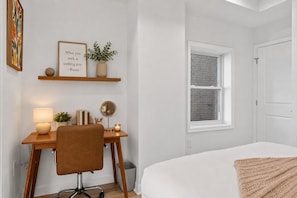 A bedroom with a bed, a desk with a chair, a window, and a door. - Brand New 3BR Luxury DC Rowhome w/ Rooftop Patio• 5-10 mins from top attractions (Washington)
