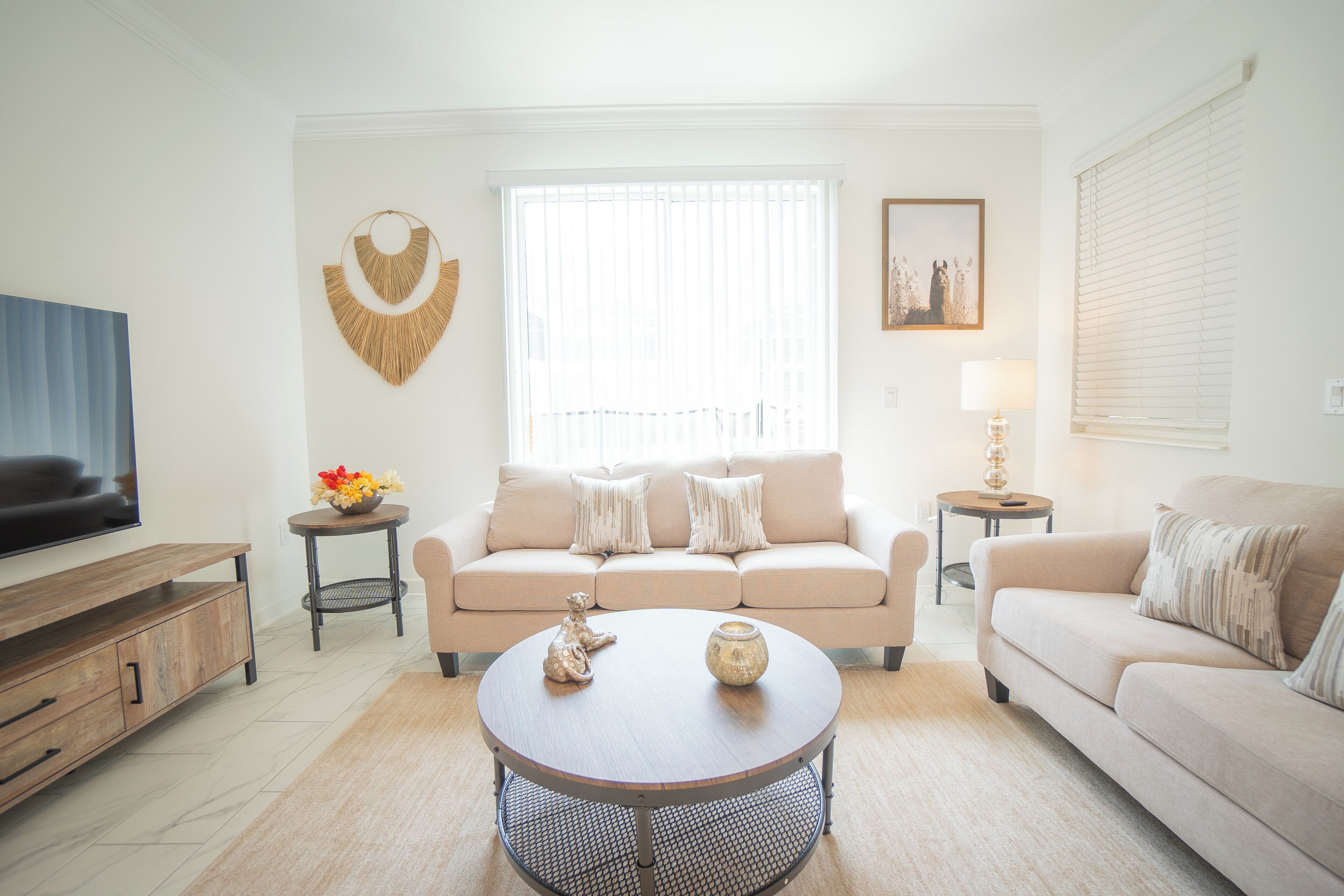 A living room with a sofa, coffee table, TV, and decorative items.