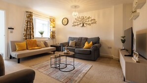 A modern living room with a sofa, a coffee table, and a TV. - E-Solace-  Etihad-Coop LIVE-Free Parking-Pool Table (Manchester)