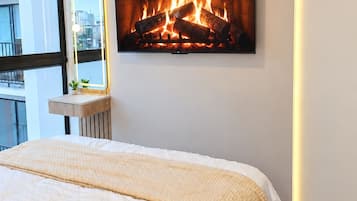 Una camera da letto con un letto, un camino a muro e una finestra.