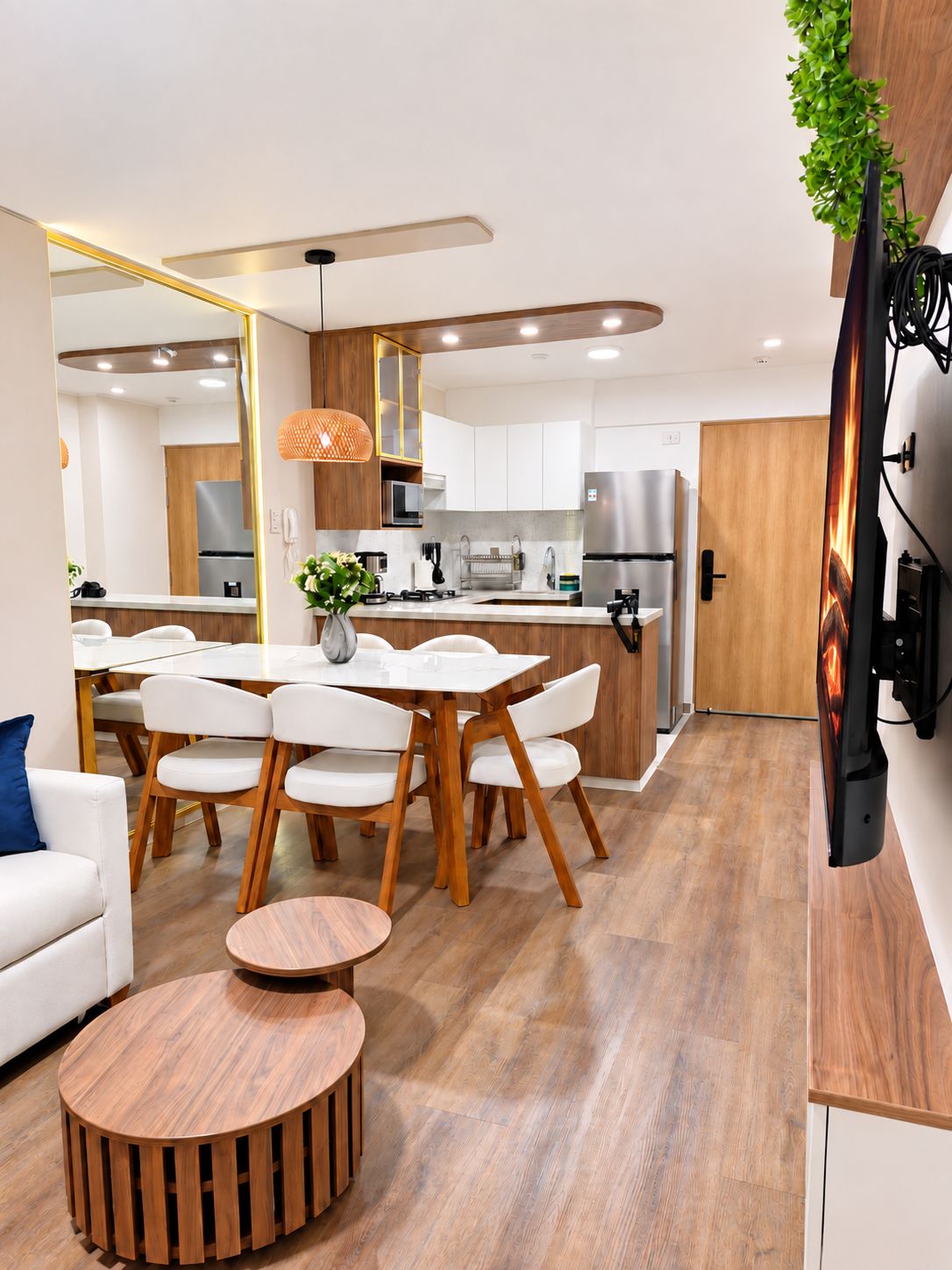 Una cocina moderna con armarios blancos, un refrigerador de acero inoxidable y una puerta de madera.