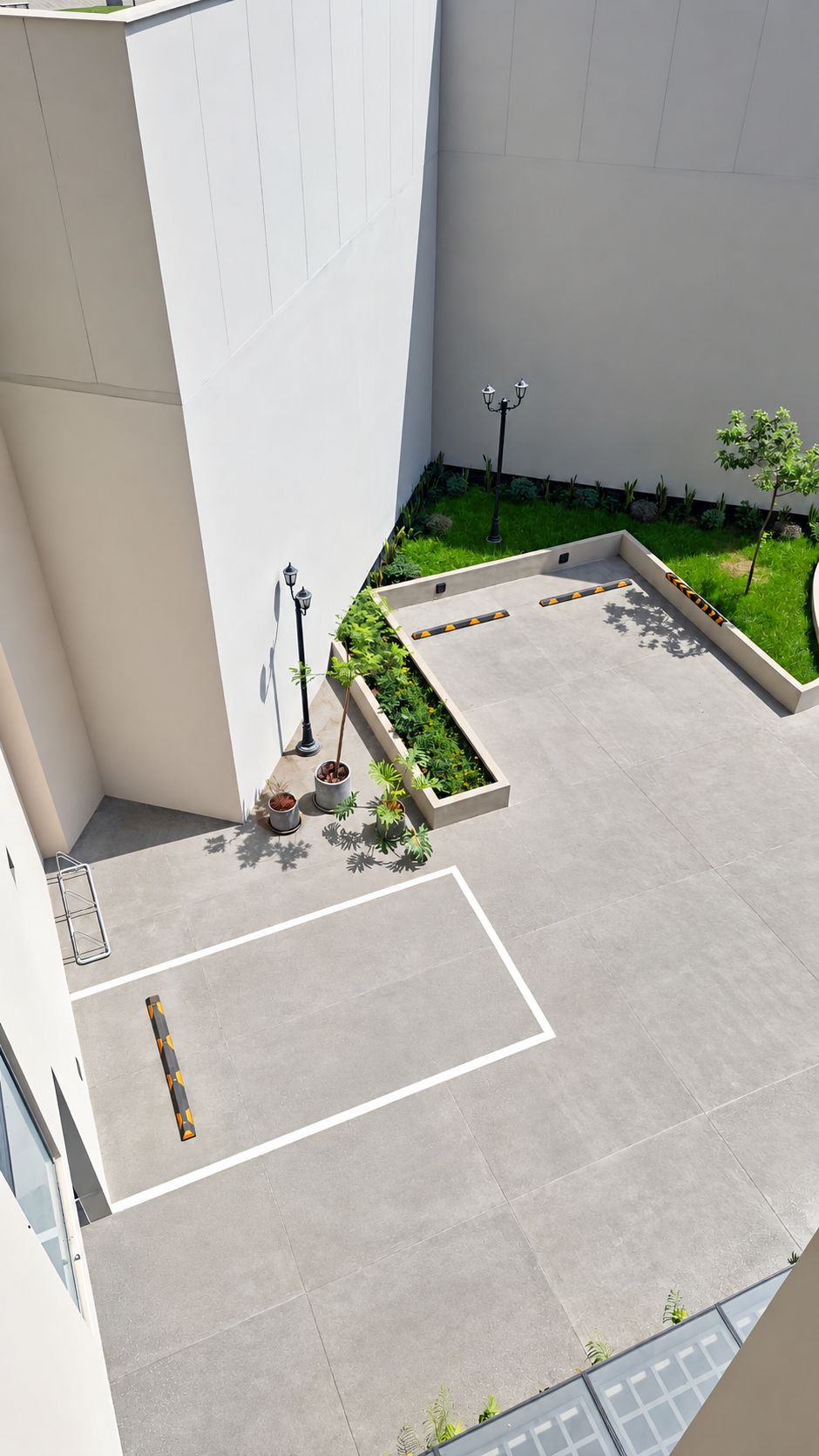 Un patio con suelo empedrado, plantas en macetas y una farola.