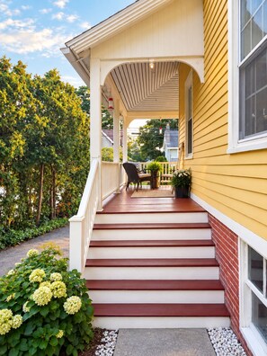 A yellow house with a porch, steps, and a small table with chairs. - The Yellow House - Walk to Downtown Mystic (Stonington)
