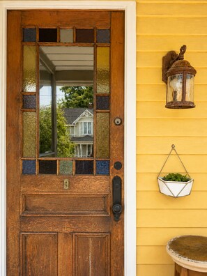 A wooden door with a glass panel and a metal bell. - The Yellow House - Walk to Downtown Mystic (Stonington)