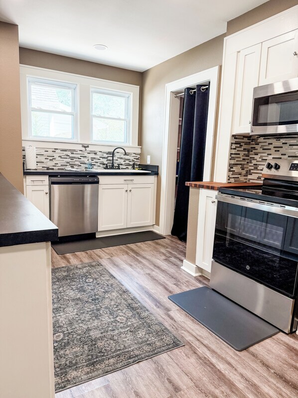 A modern kitchen with a dishwasher, oven, and microwave.