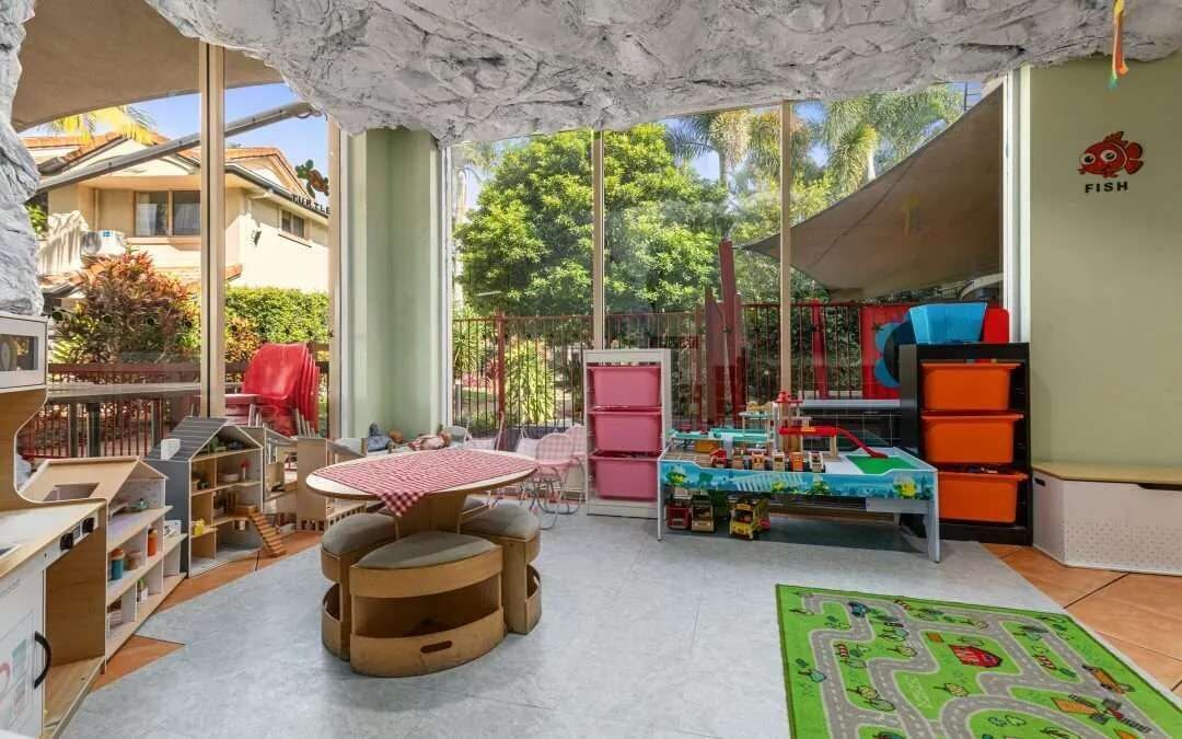 A children's playroom with a table, chairs, and toys.