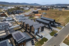 Zona residencial con casas modernas, paneles solares y una calle.