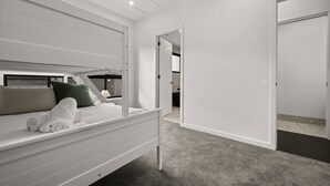 Una camera da letto con un letto a castello, una cabina armadio e una porta che dà su un'altra stanza.