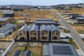 A residential area with modern houses, a road, and solar panels. - Snowy Mountains Retreat with Indoor Fireplace (Jindabyne)