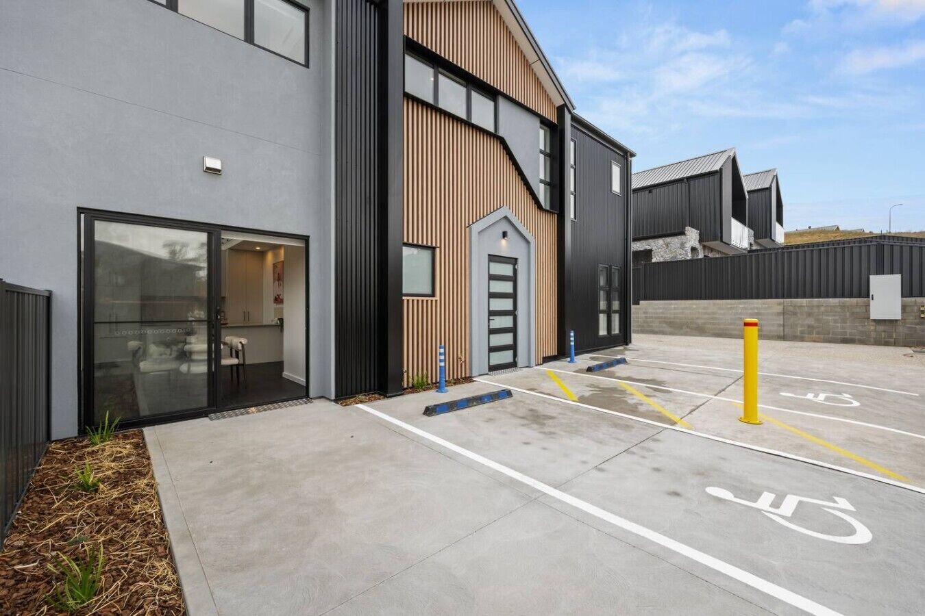 A modern building with a parking area, including a handicapped parking space.