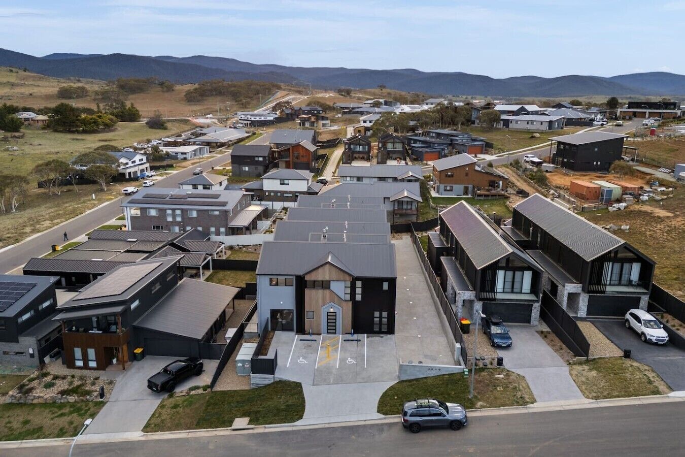 A residential area with modern houses, a parking lot, and a road.
