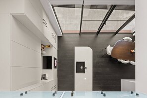 Ein modernes Badezimmer mit Dachfenster, einem weißen Waschtisch und einer dunklen Wand.