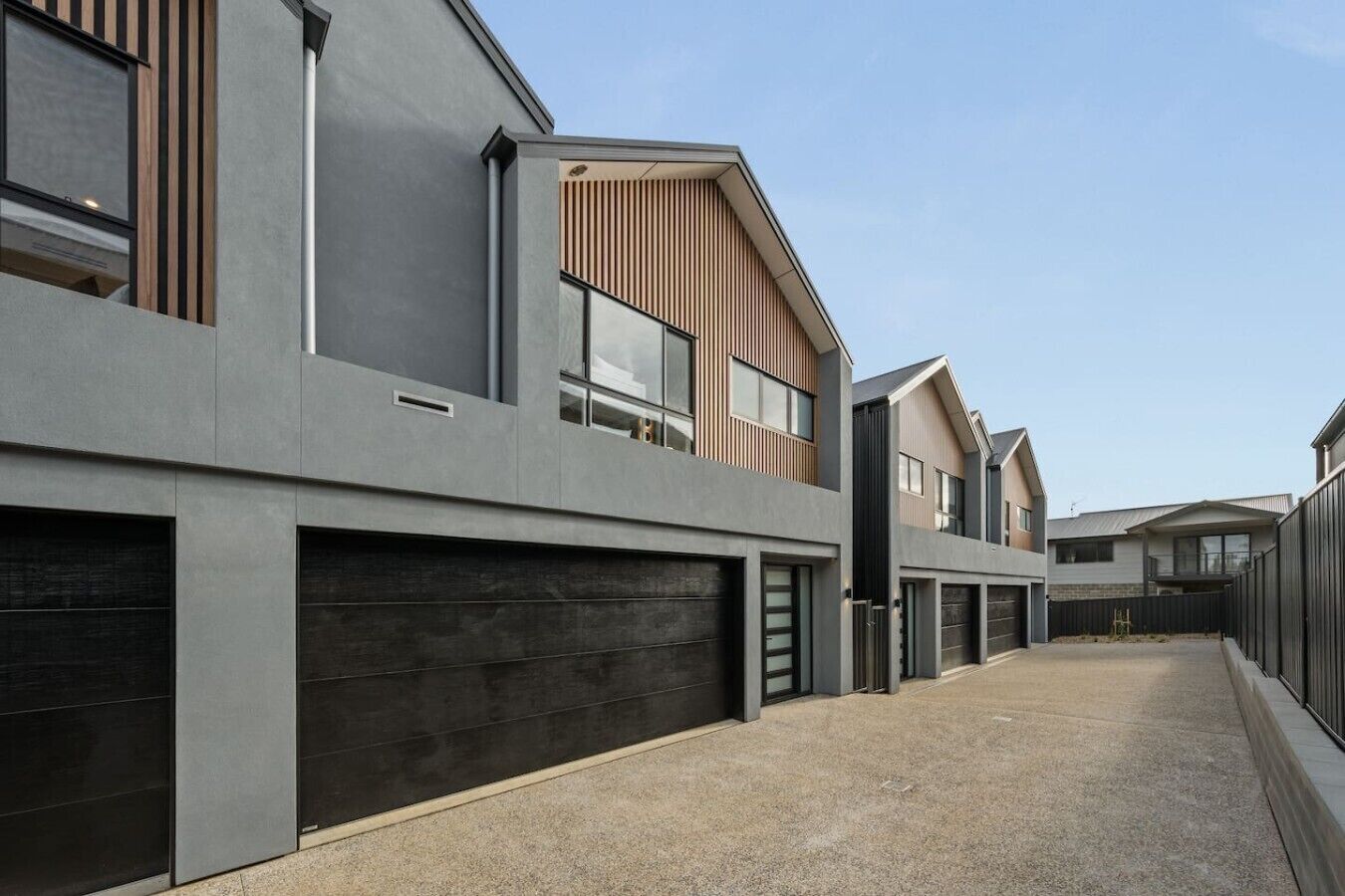 A modern residential building with a flat roof, large windows, and a concrete facade.