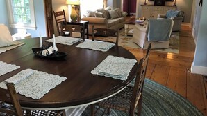A dining table with lace placemats, a candle centerpiece, and a wooden chair. - Historic VT Retreat | Hot Tub, Views, Near Skiing (Mount Holly)
