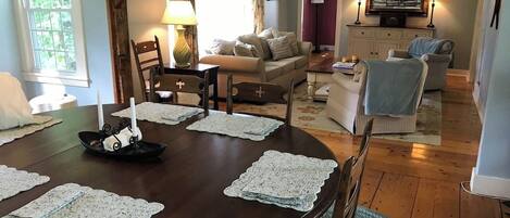 Una mesa de comedor con individuales de encaje, un centro de mesa con velas y una silla de madera.