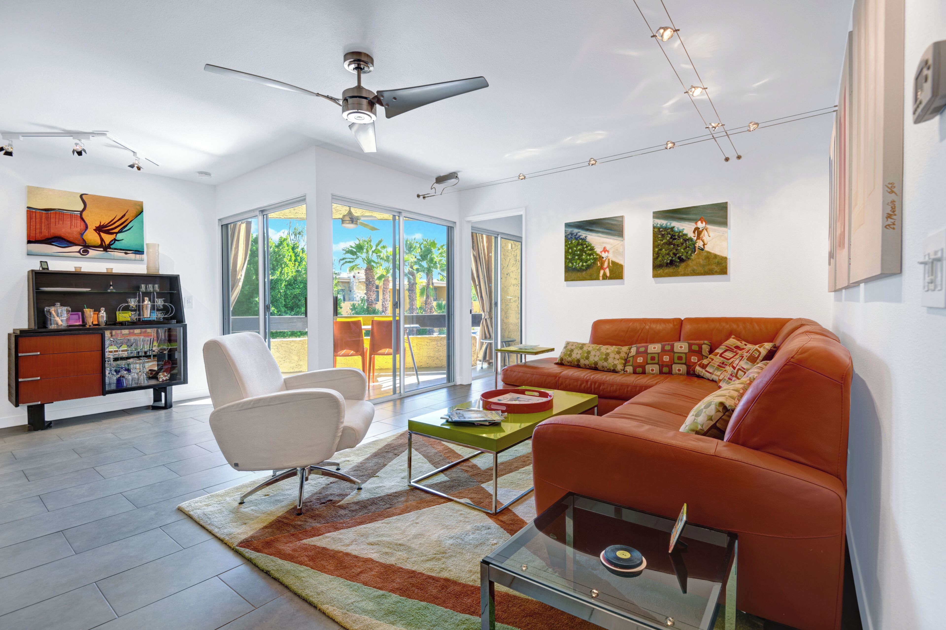 A modern living room with a sofa, a chair, a coffee table, and a ceiling fan.