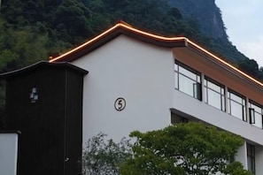 A building with a white facade, a dark brown door, and a number '5' on the wall.