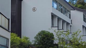 A modern building with a flat facade, multiple windows, and a visible door.