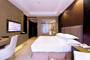 Une chambre d’hôtel moderne avec un grand lit, une table de chevet et un téléviseur fixé au mur.