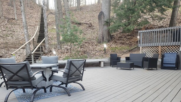 A deck with outdoor furniture, a staircase, and a wooden deck.