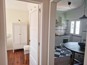Une cuisine avec un carrelage à motifs, une table à manger et un meuble blanc.