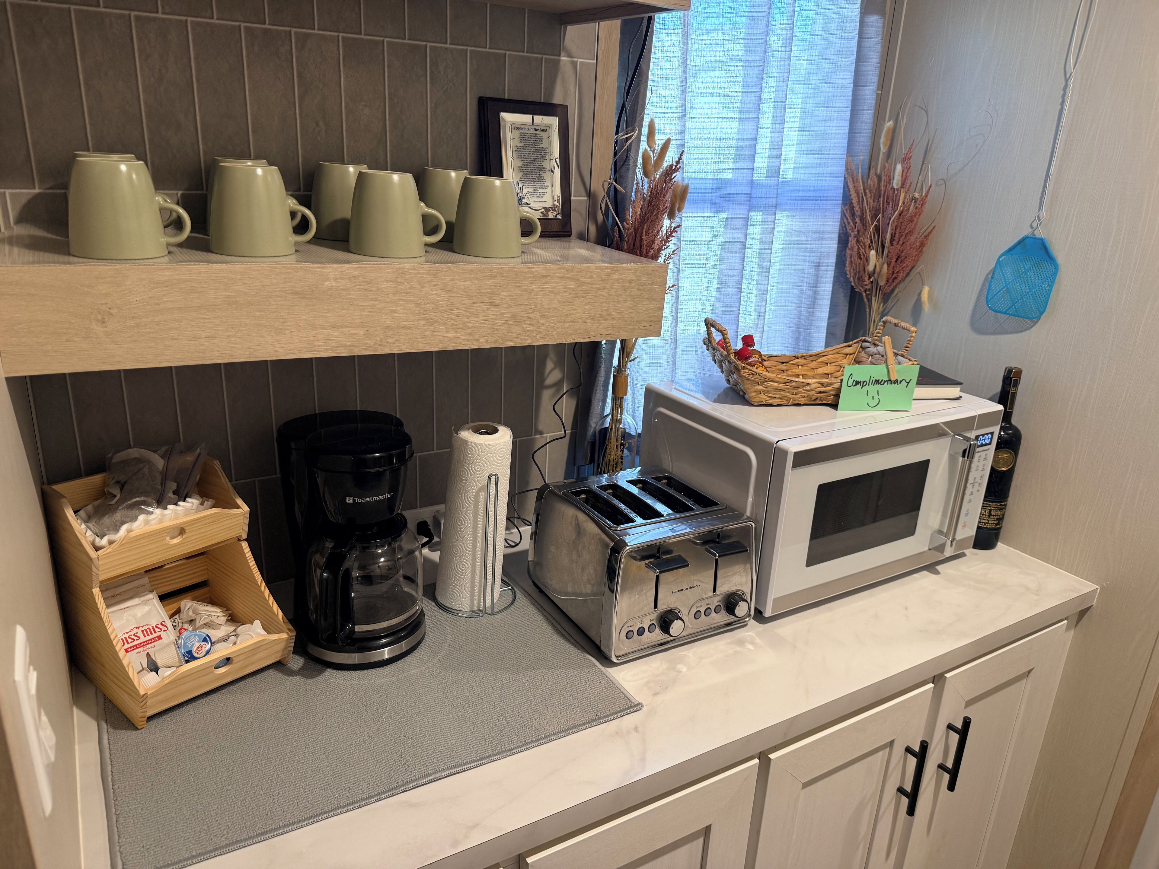 A kitchen with a toaster, a coffee maker, and a microwave on the counter.