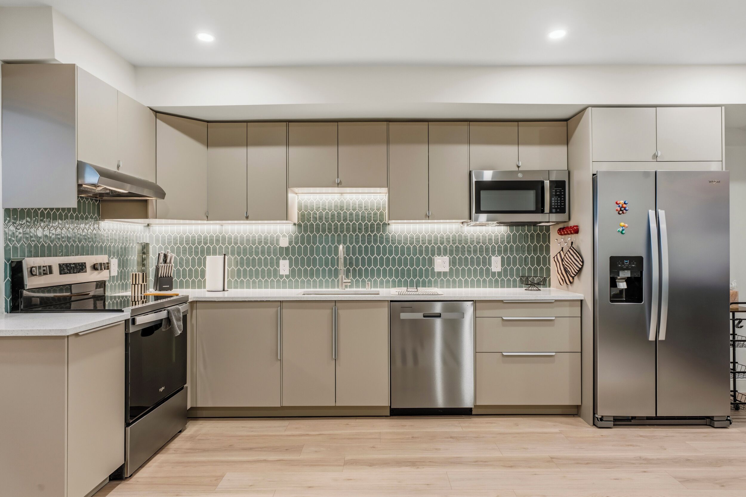 A modern kitchen with stainless steel appliances, a dishwasher, and a microwave.