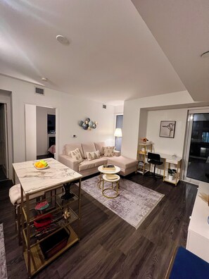 Een moderne woonkamer met een bank, een salontafel en een eethoek met een tafel en stoelen.