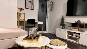 A modern living room with a sofa, a coffee table, a TV, and a small side table.