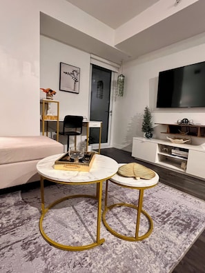 A modern living room with a sofa, a coffee table, a TV, and a small side table.