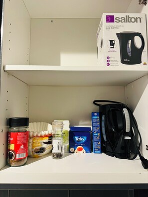 A shelf with a kettle, a box, and various food items. - 1 Bedroom condo in the heart of Downtown Toronto (Toronto)