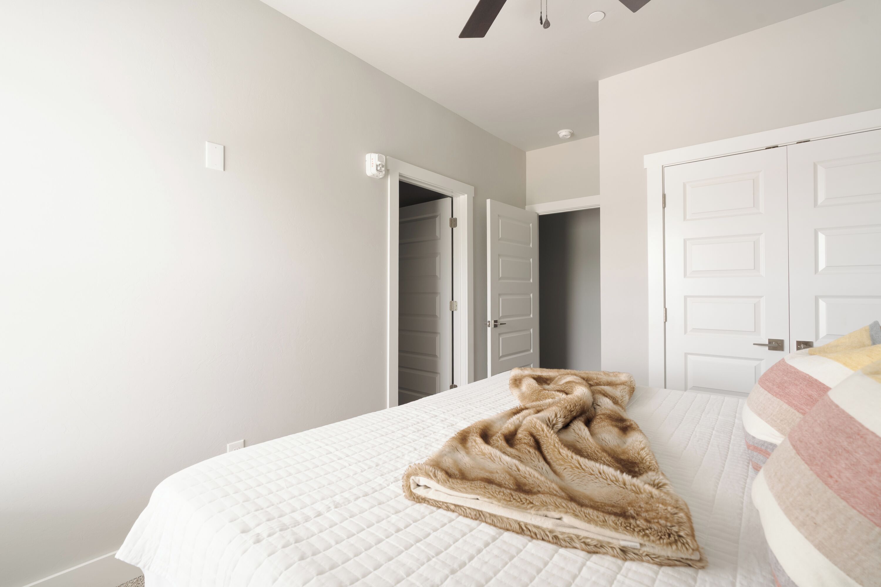 A bedroom with a bed, a door, and a closet.