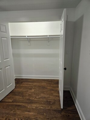 A room with a wooden floor, a white door, and a closet with a white door. - American Tudor Revival, 8-beds, 4 bedrooms, 3 sofa beds, 3 full bath, all new. (Downers Grove)