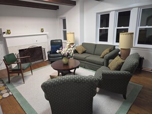 A living room with a sofa, chairs, a coffee table, and a vase with flowers. - American Tudor Revival, 8-beds, 4 bedrooms, 3 sofa beds, 3 full bath, all new. (Downers Grove)