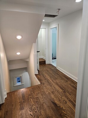 A staircase leading to a second floor with wooden flooring and white walls. - American Tudor Revival, 8-beds, 4 bedrooms, 3 sofa beds, 3 full bath, all new. (Downers Grove)