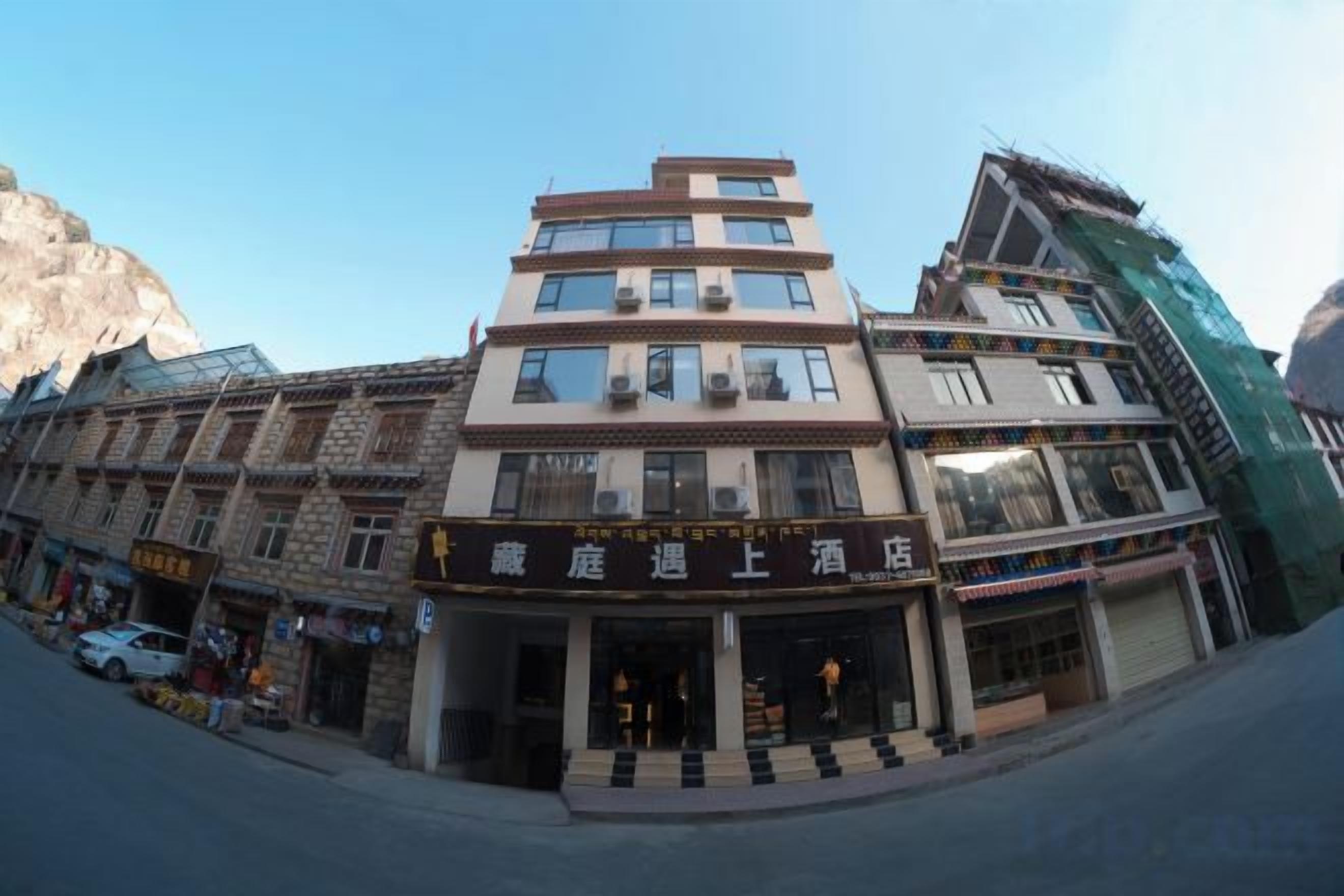 A hotel with multiple floors, a ground-level entrance, and a visible storefront.