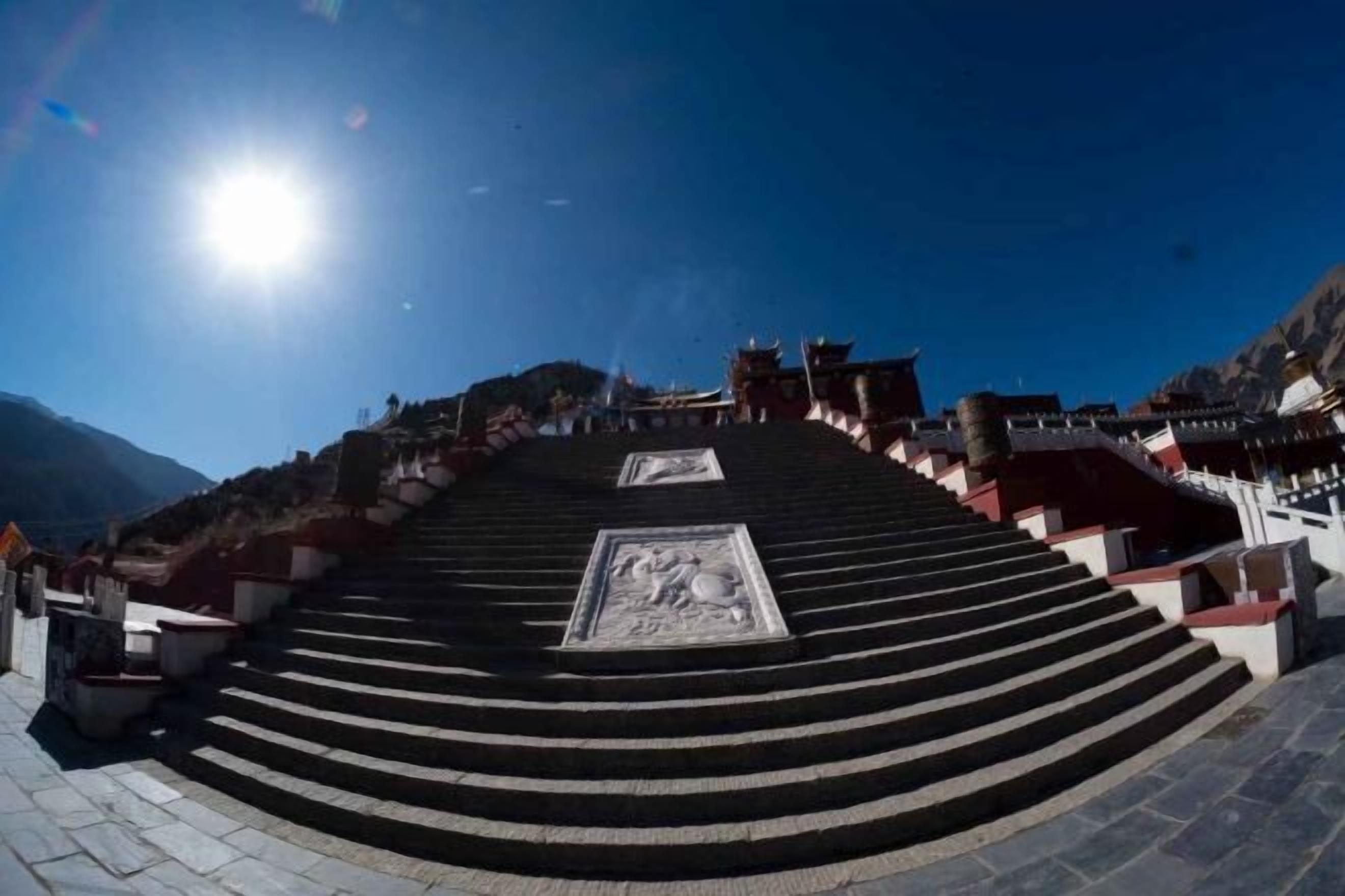 A set of stairs leading up to a building with a clear sky above.
