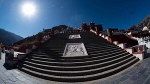 Un escalier menant à un bâtiment, avec un ciel dégagé au-dessus.