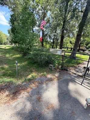 A fenced park area with a dog, trees, and a flag. - The Escape @ Vanderosa (Montgomery County)