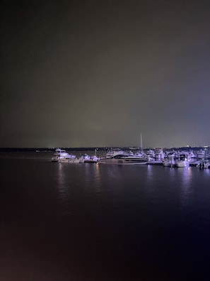 A marina at night with several yachts docked.