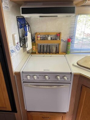 Una cocina compacta con estufa, horno y una pequeña zona de encimera.