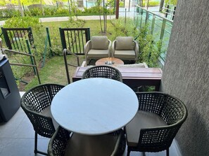A patio with a round table and four chairs, surrounded by greenery and a pool view. - ⭐ Muro Alto Beach Resort near Porto de Galinhas | Pool & Garden (Ipojuca)